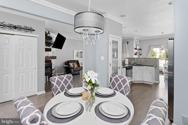 14 Barclay Ct, Bordentown, NJ 08505 - dining room featuring a chandelier, crown molding, a glass covered fireplace, dark wood-style flooring, and recessed lighting