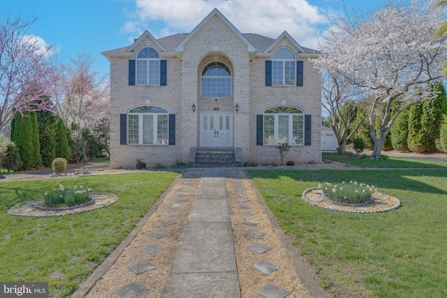 view of front of house with brick siding and a front yard