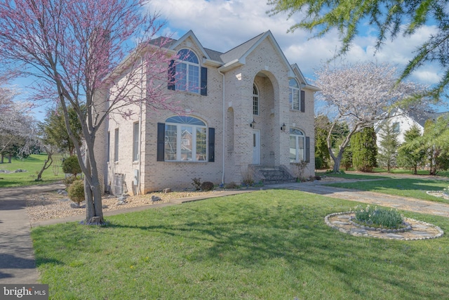 view of front of home with brick siding and a front lawn