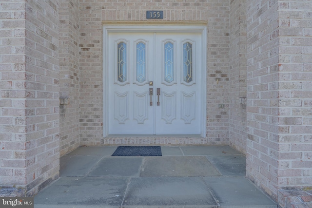 property entrance with brick siding and french doors