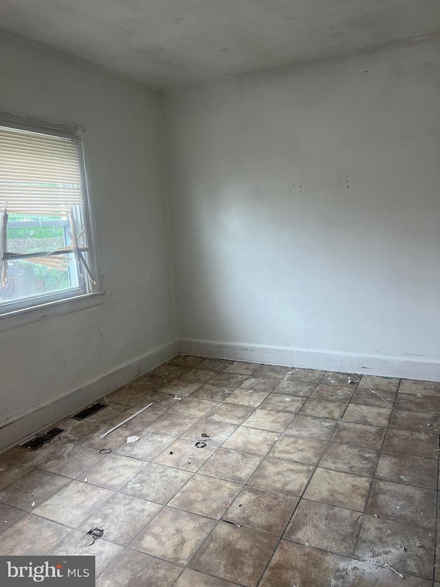 spare room with baseboards