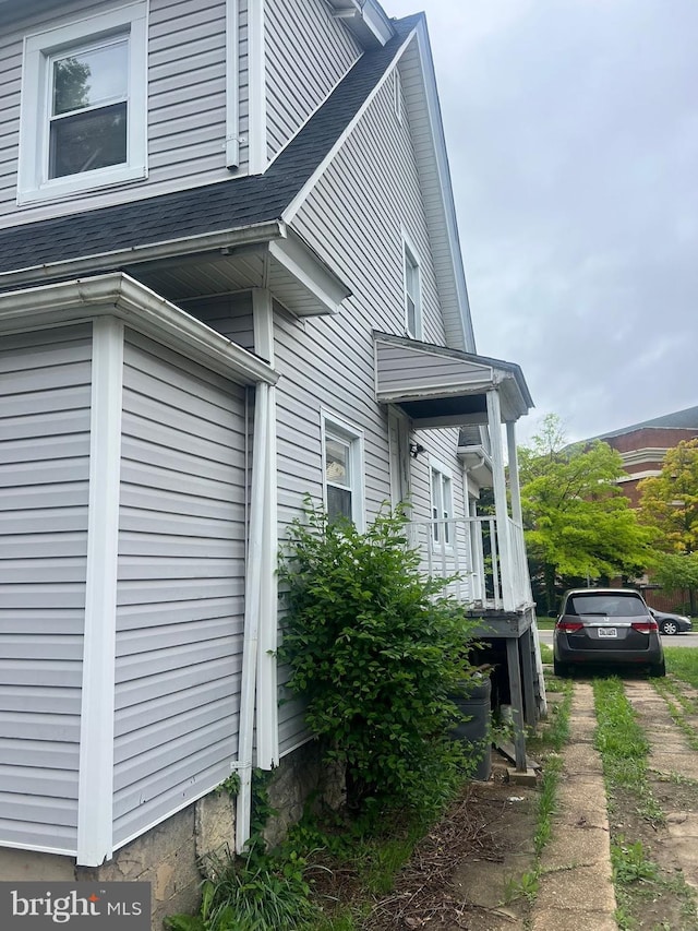 view of side of property with roof with shingles