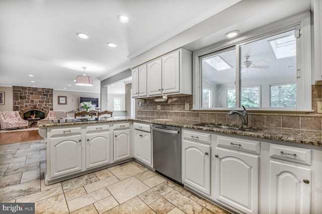 981 Old Holly Dr, Great Falls, VA 22066 - kitchen with dishwasher, a sink, a skylight, a peninsula, and backsplash
