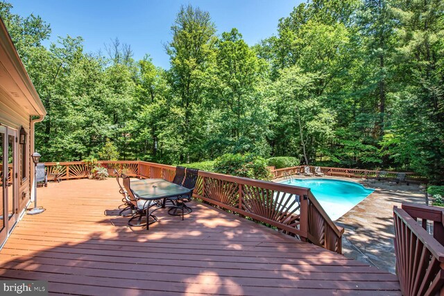 981 Old Holly Dr, Great Falls, VA 22066 - wooden terrace featuring an outdoor pool, outdoor dining area, and a wooded view
