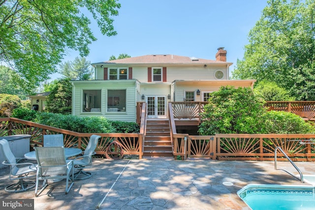 981 Old Holly Dr, Great Falls, VA 22066 - rear view of property with a wooden deck, stairway, a patio area, a chimney, and an outdoor pool
