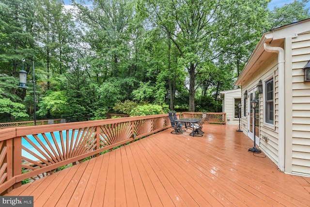 981 Old Holly Dr, Great Falls, VA 22066 - wooden deck with outdoor dining space and view of wooded area