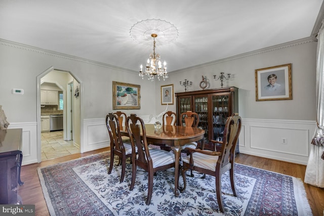 981 Old Holly Dr, Great Falls, VA 22066 - dining area with arched walkways, a wainscoted wall, a chandelier, a decorative wall, and crown molding