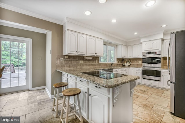 981 Old Holly Dr, Great Falls, VA 22066 - kitchen with a peninsula, stainless steel appliances, crown molding, white cabinetry, and backsplash