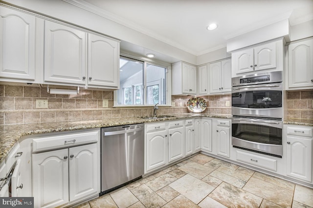 981 Old Holly Dr, Great Falls, VA 22066 - kitchen with appliances with stainless steel finishes, a sink, crown molding, white cabinetry, and light stone counters