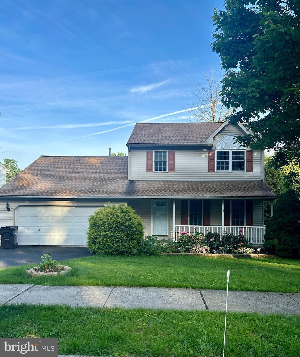 4180 Hunters Run Blvd, Reading, PA 19606 - traditional home with an attached garage, covered porch, a front yard, asphalt driveway, and a shingled roof