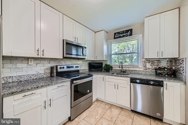 1201 Cobb Rd, Baltimore, MD 21208 - kitchen featuring stainless steel appliances, a sink, white cabinets, dark stone countertops, and backsplash