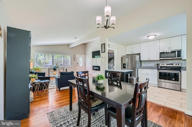 1201 Cobb Rd, Baltimore, MD 21208 - dining room with lofted ceiling, light wood-style floors, and a chandelier