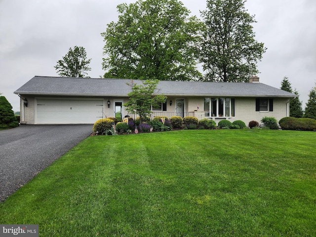 single story home featuring asphalt driveway, an attached garage, a front lawn, brick siding, and a chimney