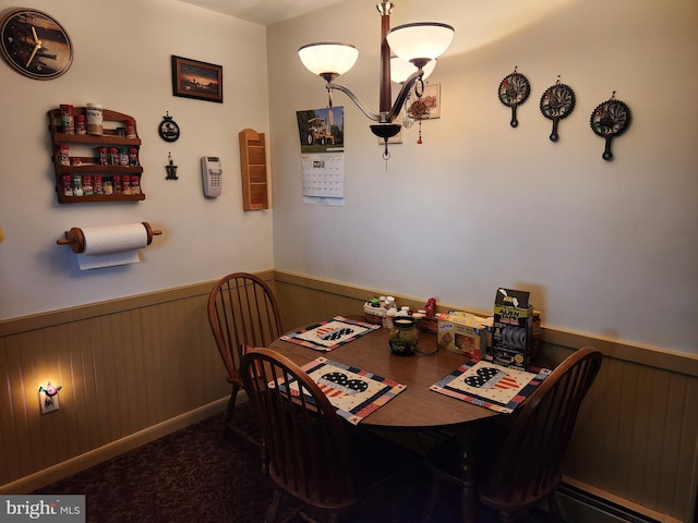 carpeted dining space featuring a wainscoted wall, a chandelier, and wooden walls