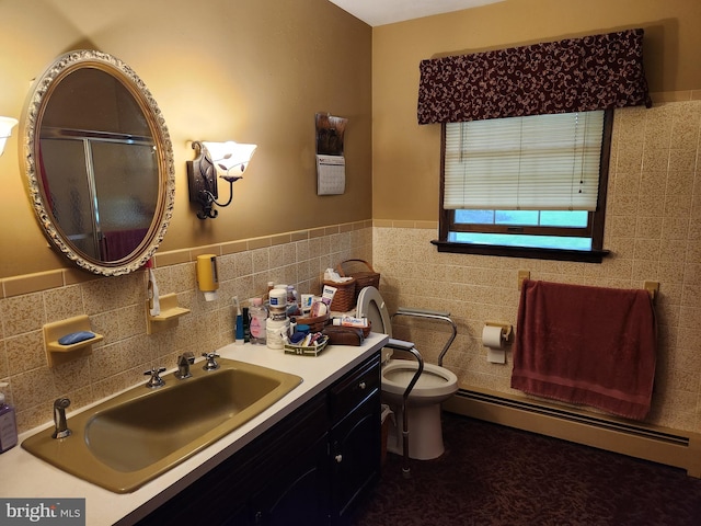 bathroom with baseboard heating, tile walls, vanity, toilet, and a wainscoted wall