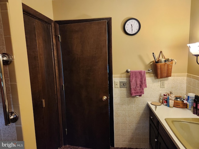 bathroom featuring vanity, a wainscoted wall, and tile walls