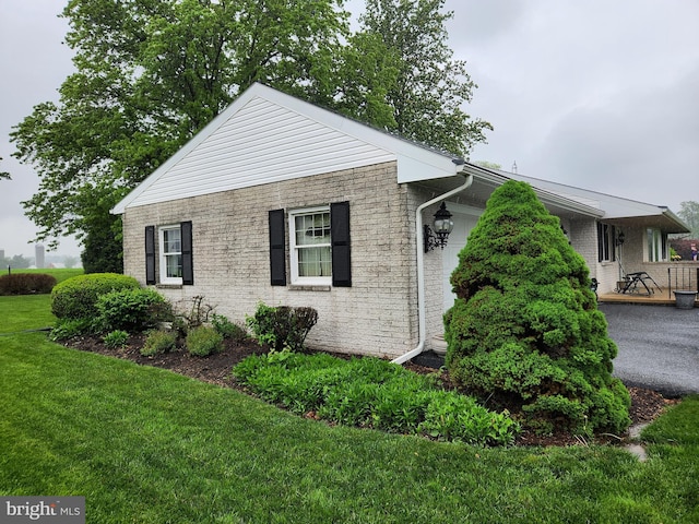 view of side of home with a yard and brick siding