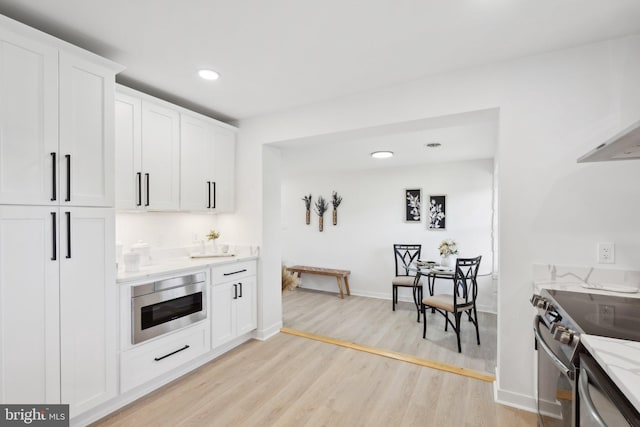 214 Dillard Ct, Front Royal, VA 22630 - kitchen with oven, light wood-type flooring, stainless steel electric range, white cabinetry, and light stone counters