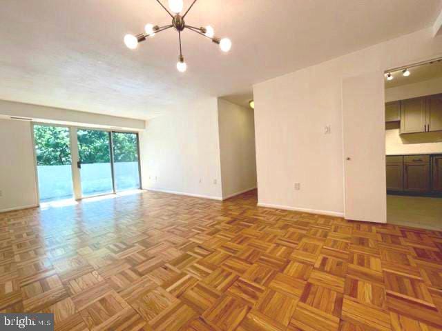 700 7th St SW Unit 507, Washington, DC 20024 - unfurnished living room with a chandelier and baseboards