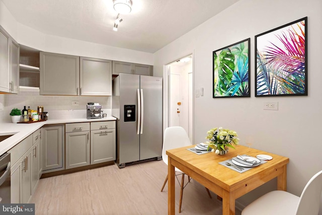 700 7th St SW Unit 507, Washington, DC 20024 - kitchen featuring stainless steel refrigerator with ice dispenser, gray cabinets, light wood-type flooring, and light countertops