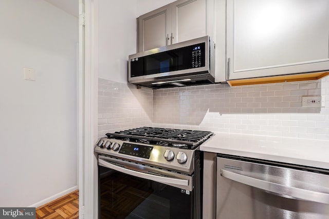 700 7th St SW Unit 507, Washington, DC 20024 - kitchen with appliances with stainless steel finishes, light countertops, decorative backsplash, gray cabinets, and baseboards