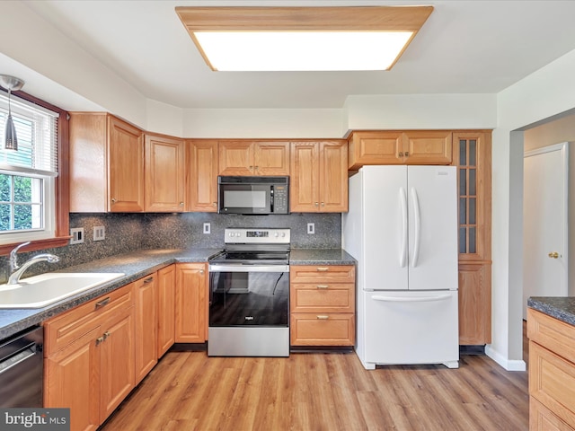 719 Loblolly Ln, Reading, PA 19607 - kitchen featuring black appliances, a sink, light wood-style flooring, decorative backsplash, and dark countertops