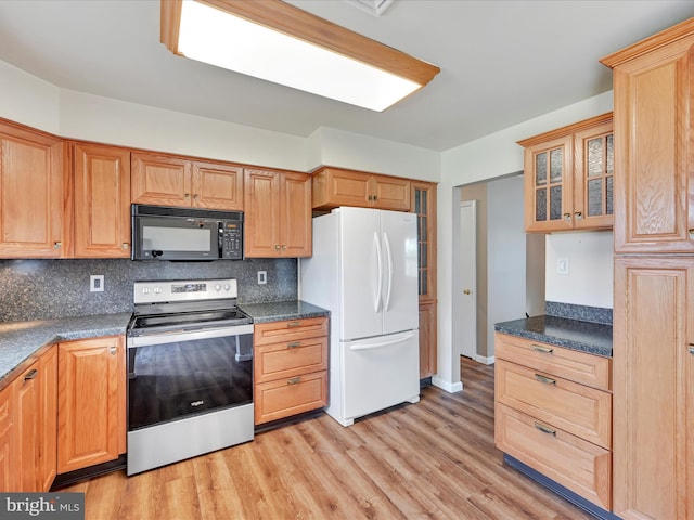 719 Loblolly Ln, Reading, PA 19607 - kitchen with stainless steel range with electric stovetop, black microwave, freestanding refrigerator, light wood-style flooring, and decorative backsplash