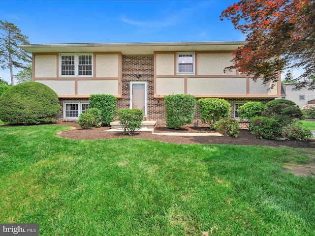719 Loblolly Ln, Reading, PA 19607 - view of front of home featuring stucco siding, a front yard, and brick siding