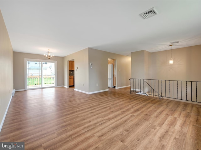 719 Loblolly Ln, Reading, PA 19607 - spare room featuring a chandelier, light wood-type flooring, and baseboards