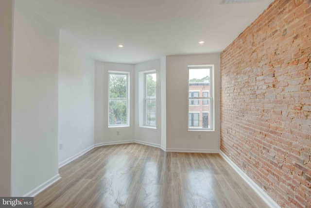 1625 Belt St, Baltimore, MD 21230 - empty room featuring plenty of natural light, brick wall, wood finished floors, and baseboards