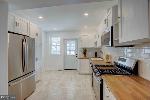 1625 Belt St, Baltimore, MD 21230 - kitchen featuring stainless steel appliances, butcher block counters, a sink, baseboards, and recessed lighting