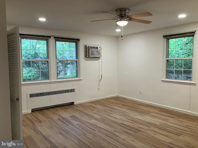 4027 Benton St NW Unit 101, Washington, DC 20007 - spare room with radiator, a ceiling fan, wood finished floors, plenty of natural light, and recessed lighting