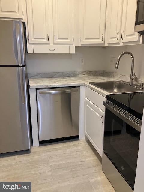 4027 Benton St NW Unit 101, Washington, DC 20007 - kitchen featuring stainless steel appliances, a sink, and white cabinets
