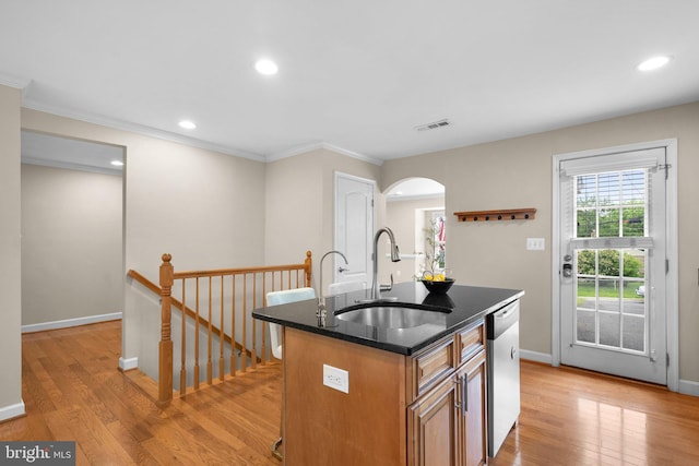 3949 Taney Ave, Alexandria, VA 22304 - kitchen featuring a sink, dishwasher, arched walkways, light wood finished floors, and a center island with sink
