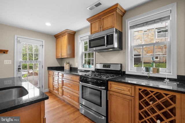 3949 Taney Ave, Alexandria, VA 22304 - kitchen featuring stainless steel appliances, light wood-style floors, dark stone countertops, brown cabinetry, and recessed lighting