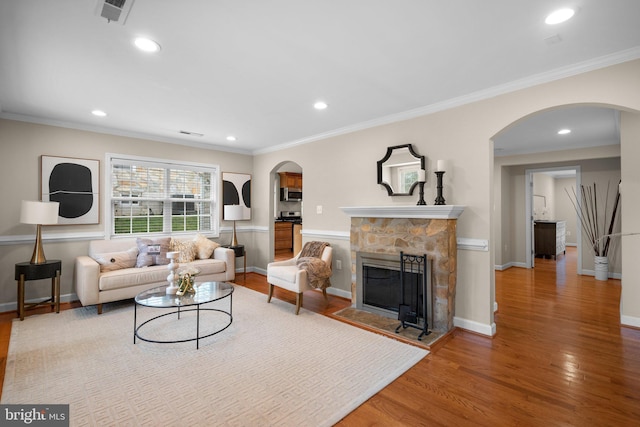 3949 Taney Ave, Alexandria, VA 22304 - living area featuring arched walkways, wood finished floors, crown molding, a fireplace, and recessed lighting