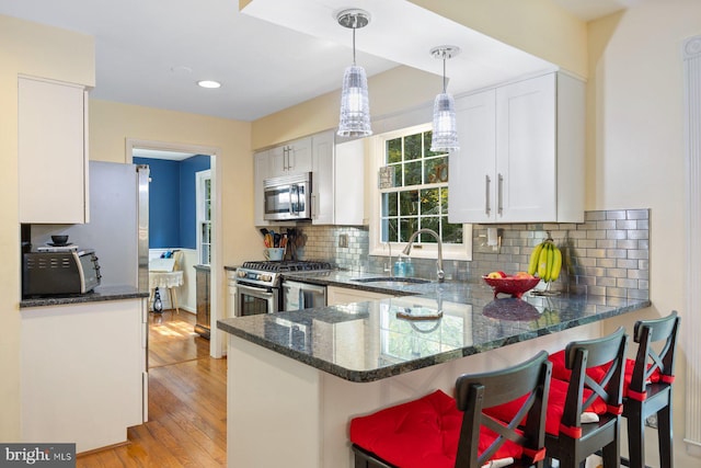 5455 Crowflock Ct, Columbia, MD 21045 - kitchen with stainless steel appliances, a sink, a peninsula, dark stone counters, and white cabinets