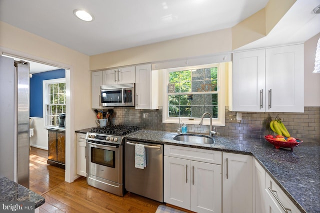 5455 Crowflock Ct, Columbia, MD 21045 - kitchen featuring appliances with stainless steel finishes, a sink, light wood-style floors, and white cabinetry