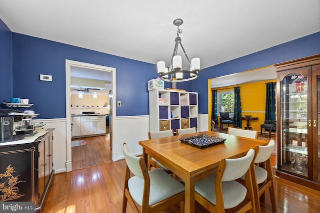 5455 Crowflock Ct, Columbia, MD 21045 - dining area featuring a wainscoted wall, a chandelier, and hardwood / wood-style floors