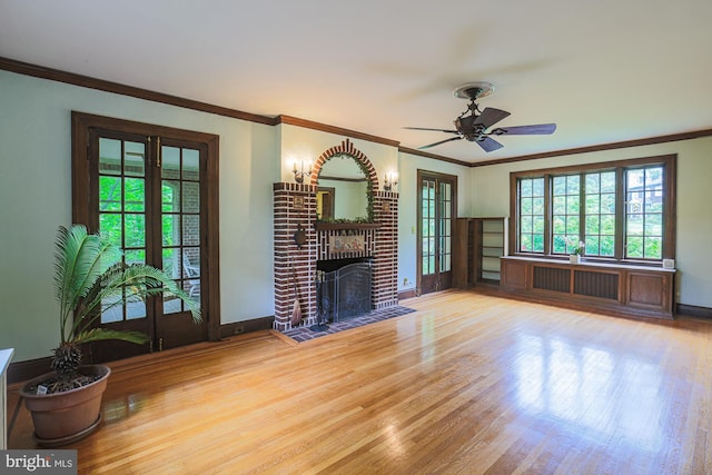 unfurnished living room featuring wood finished floors, ornamental molding, a fireplace, ceiling fan, and baseboards