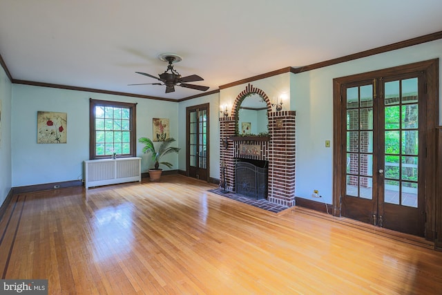 unfurnished living room featuring radiator heating unit, ornamental molding, french doors, baseboards, and wood finished floors