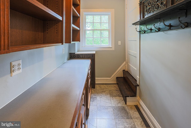 mudroom featuring baseboards and light stone finish flooring