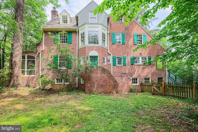 back of property featuring brick siding and a chimney