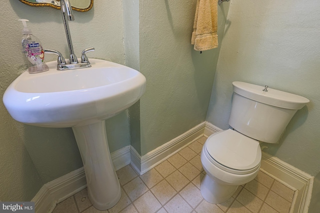 bathroom with toilet, tile patterned flooring, and baseboards