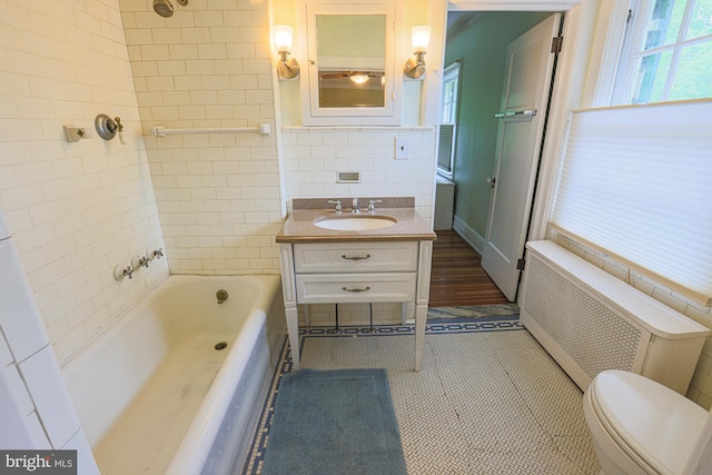 full bathroom featuring radiator, plenty of natural light, vanity, toilet, and tile walls