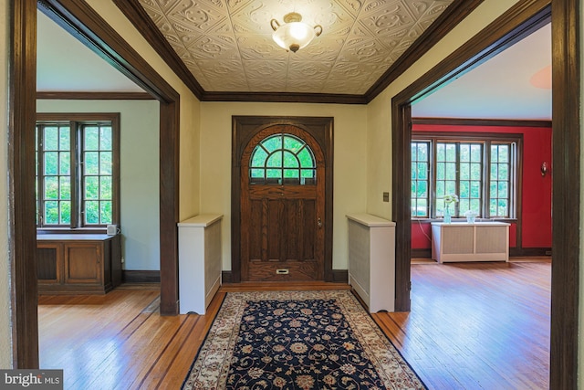 entryway featuring light wood-style flooring, baseboards, and crown molding