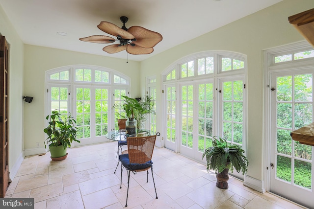 sunroom / solarium featuring french doors, stone tile flooring, and plenty of natural light