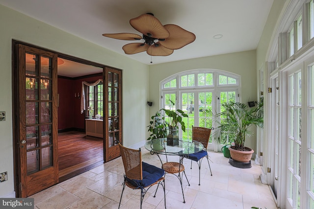 dining room featuring french doors, ceiling fan, baseboards, and stone tile floors