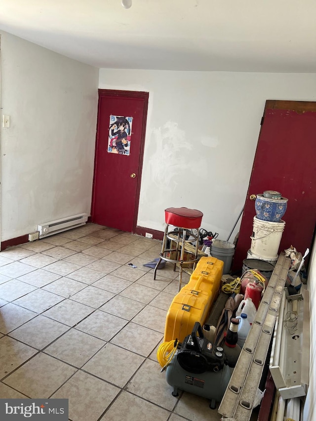 interior space with baseboard heating, light tile patterned flooring, and baseboards
