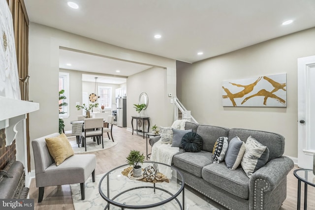 living area featuring recessed lighting, light wood-type flooring, and baseboards